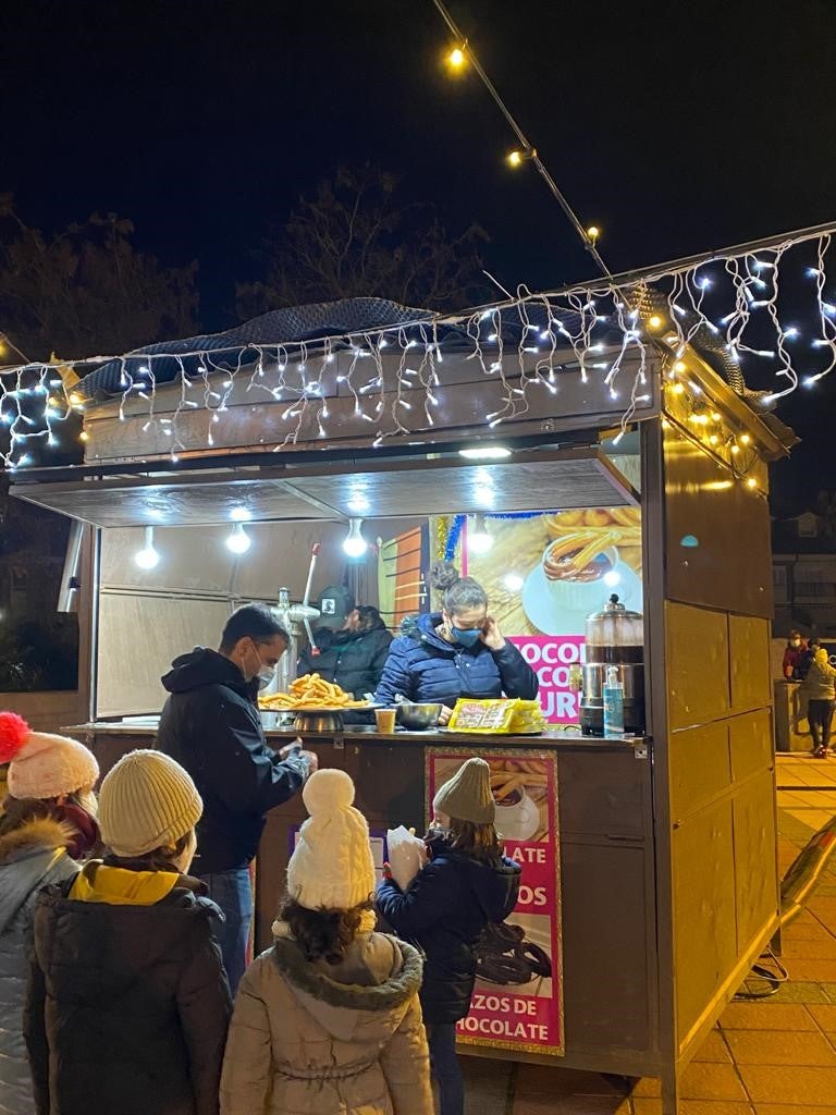 El árbol de Navidad preside el centro de la Plaza España de La Flecha rodeado de los puestos y atracciones que conforman el Mercado de Navidad de Arroyo de la Encomienda. 