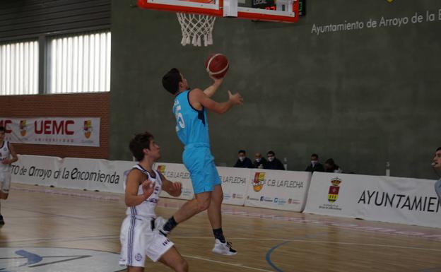 Canasta a aro pasado de Alex Pescador ante la mirada de su defensor, Álvaro García. 