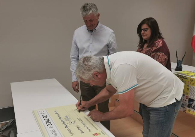 Momento en el que Sebastián Nogales y Sarbelio Fernández hacen entrega del cheque a la presidenta de ABLAA