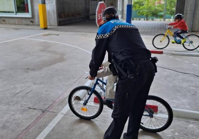 Un policía municipal ayuda a un niño a montar en bici
