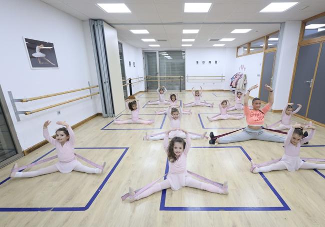 Un grupo de alumnas haciendo estiramientos en un aula de la Escuela de Danza