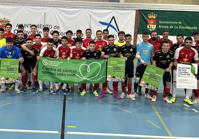 Jugadores de ambos equipos con las pancartas de la lucha contra el cáncer