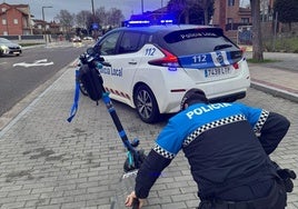 Un policía local de arroyo revisando un patinete