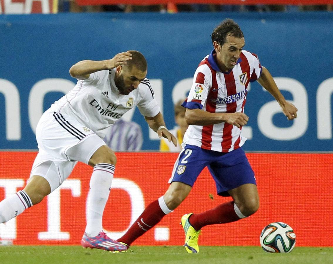 Godin conduce el balón ante Benzema.