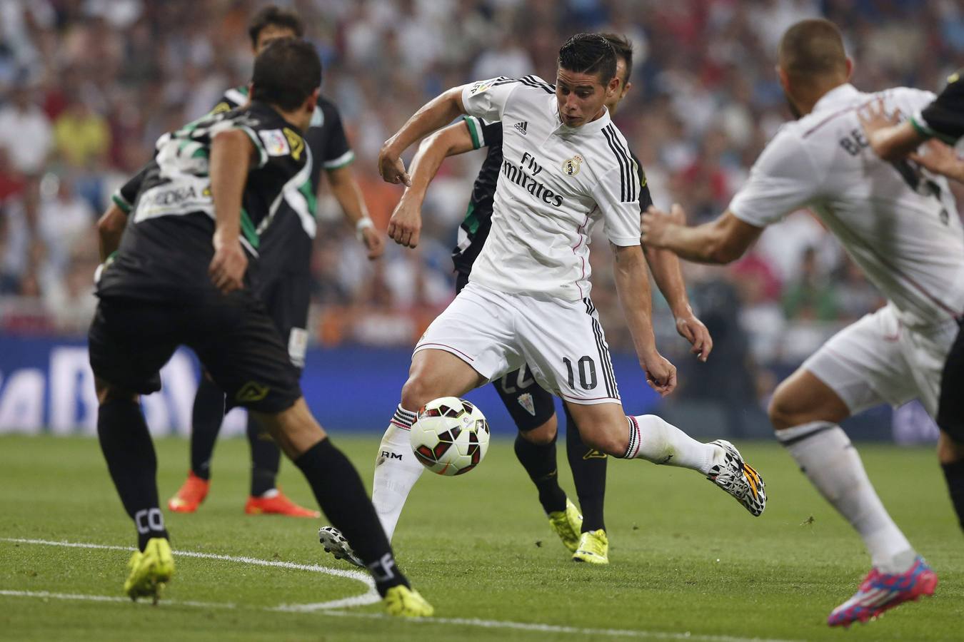 James golpea un balón entre jugadores del Córdoba.