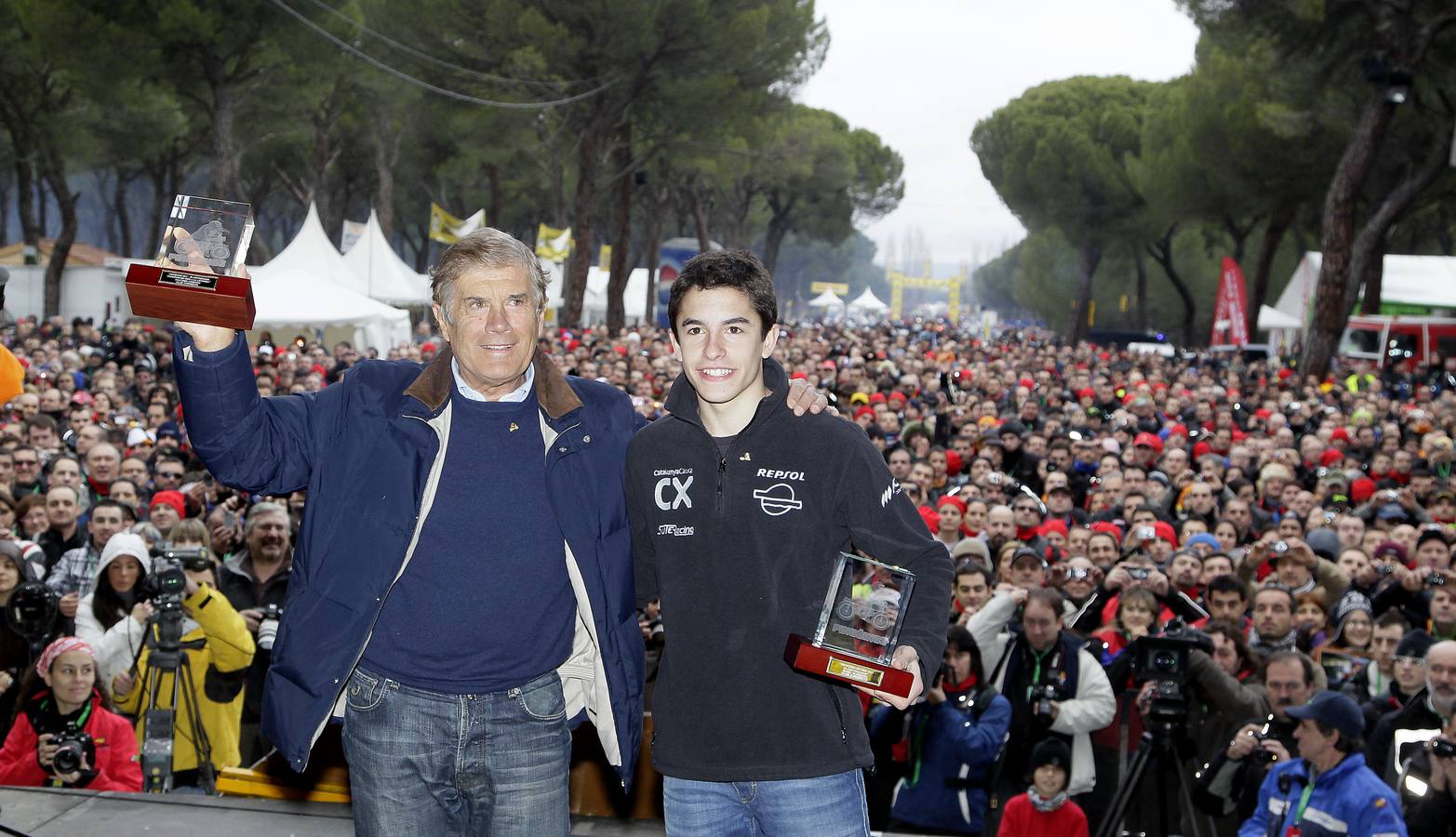 2011. Giacomo Agostini y Marc Marquez, con sus pinguinos de oro, ante una multitud que siguio la clausura de la concentracion motera Pingüinos 2011.