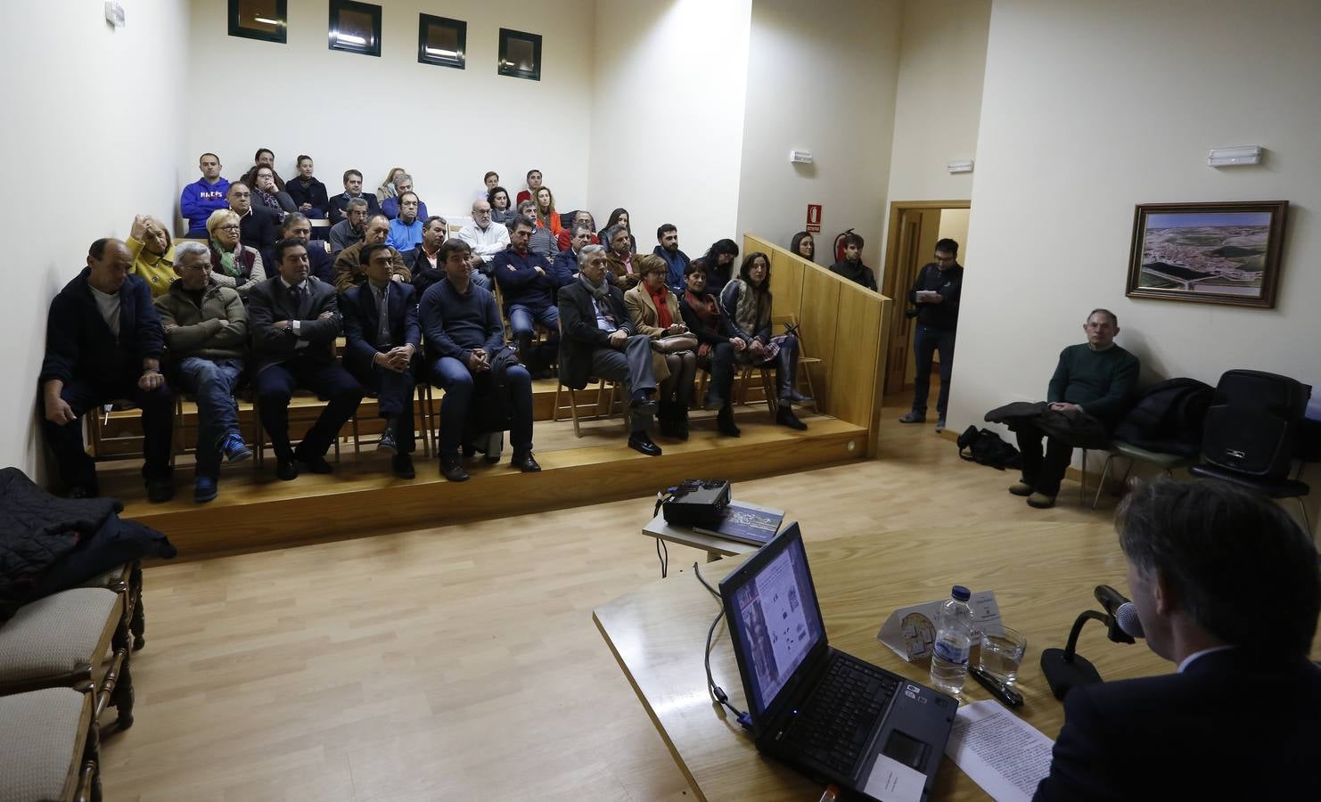 El público escucha al profesor en el salón de actos de Olivares.