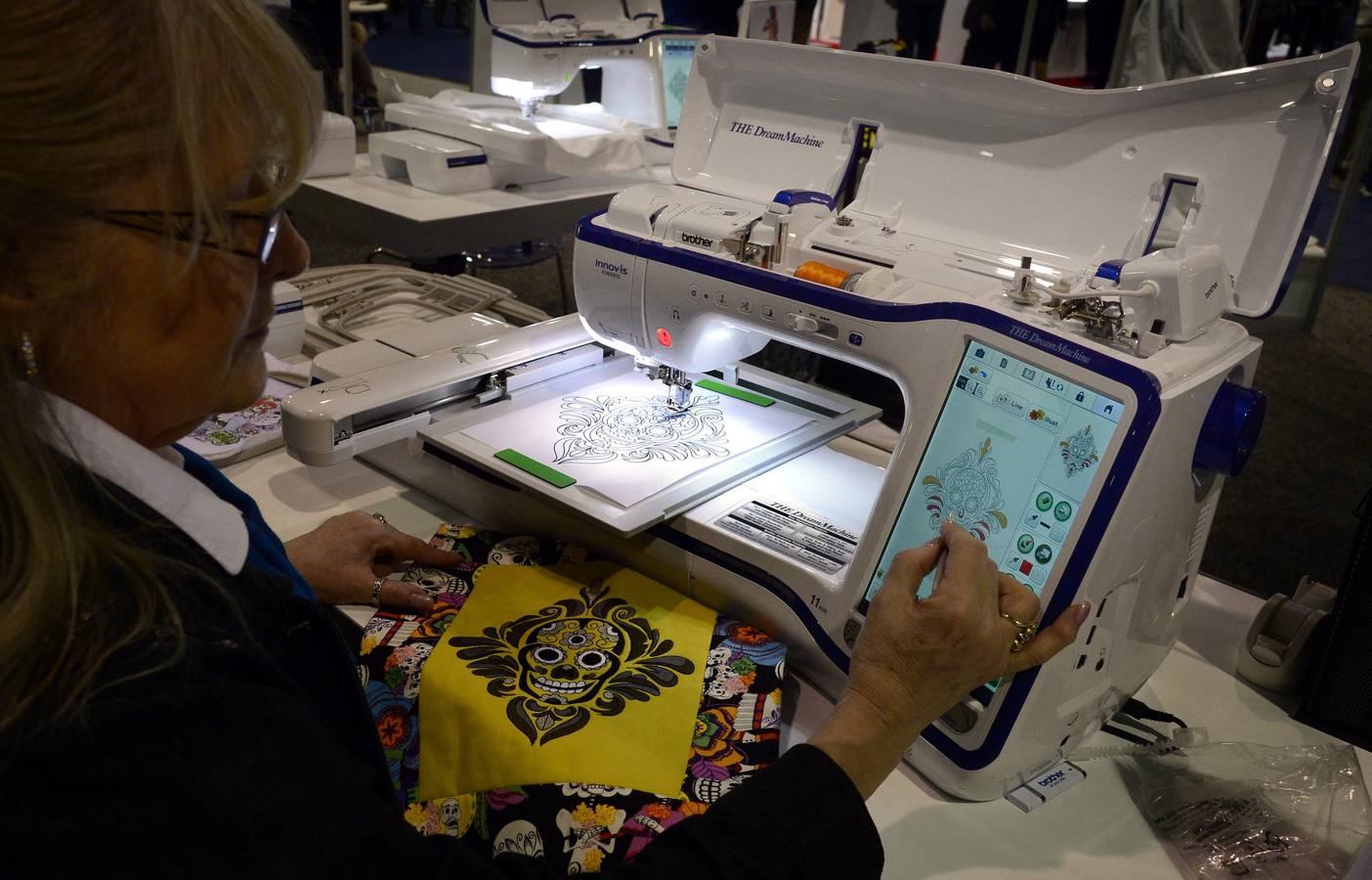 Una mujer utiliza un programa para colorear y programar un papel escaneado en la máquina de coser The Dream Machine.