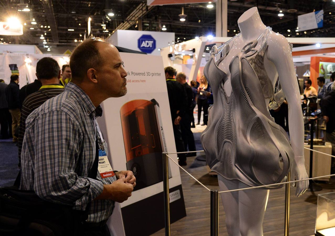 Un visitante observa un traje futurístico en 3D de Autodesk.