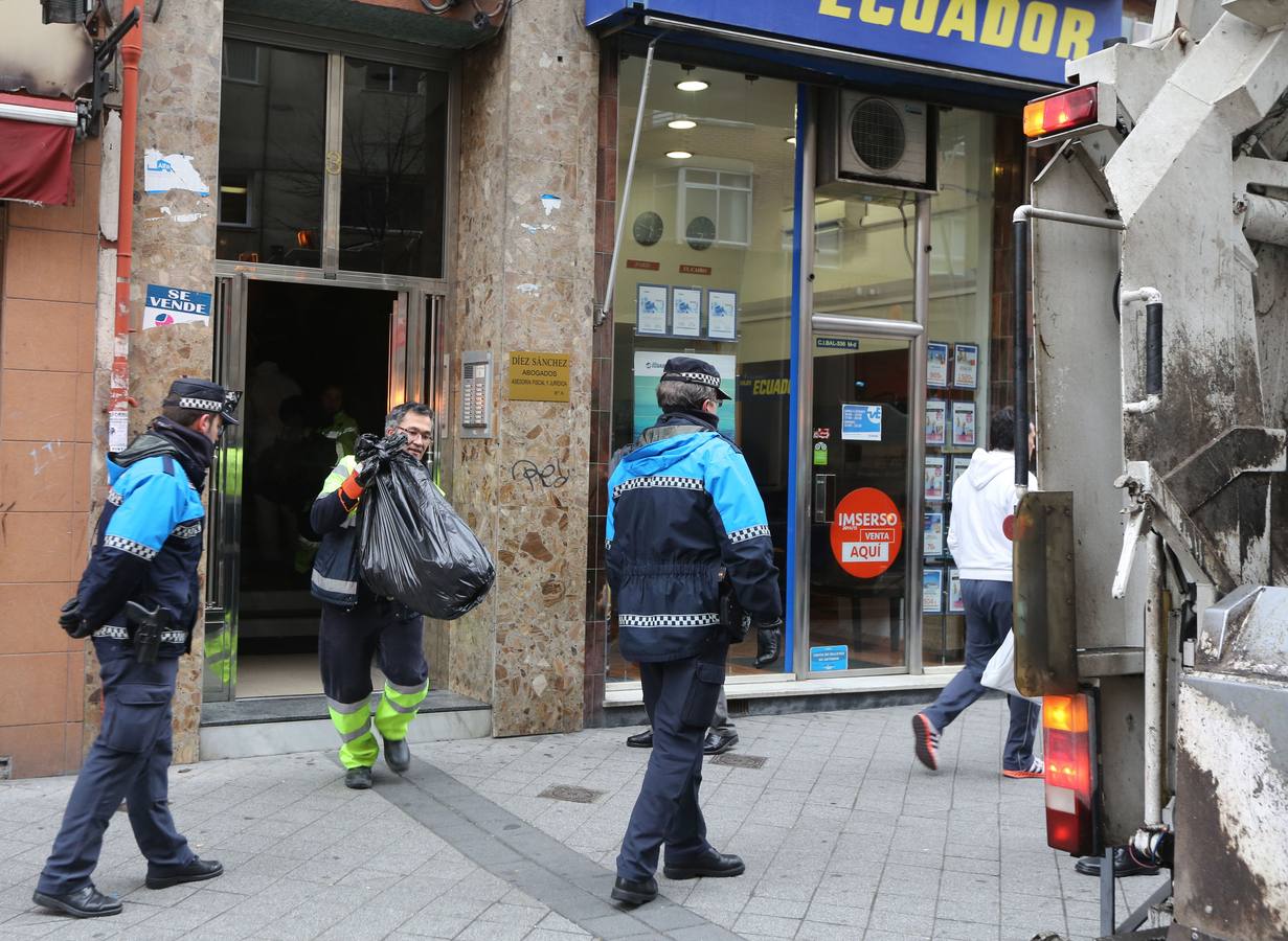Enero 2015. La policia municipal observa a los operarios de Limpieza sacar las bolsas de basura del piso de un joven que sufre el síndrome de Diógenes en la plaza de la Cruz Verde