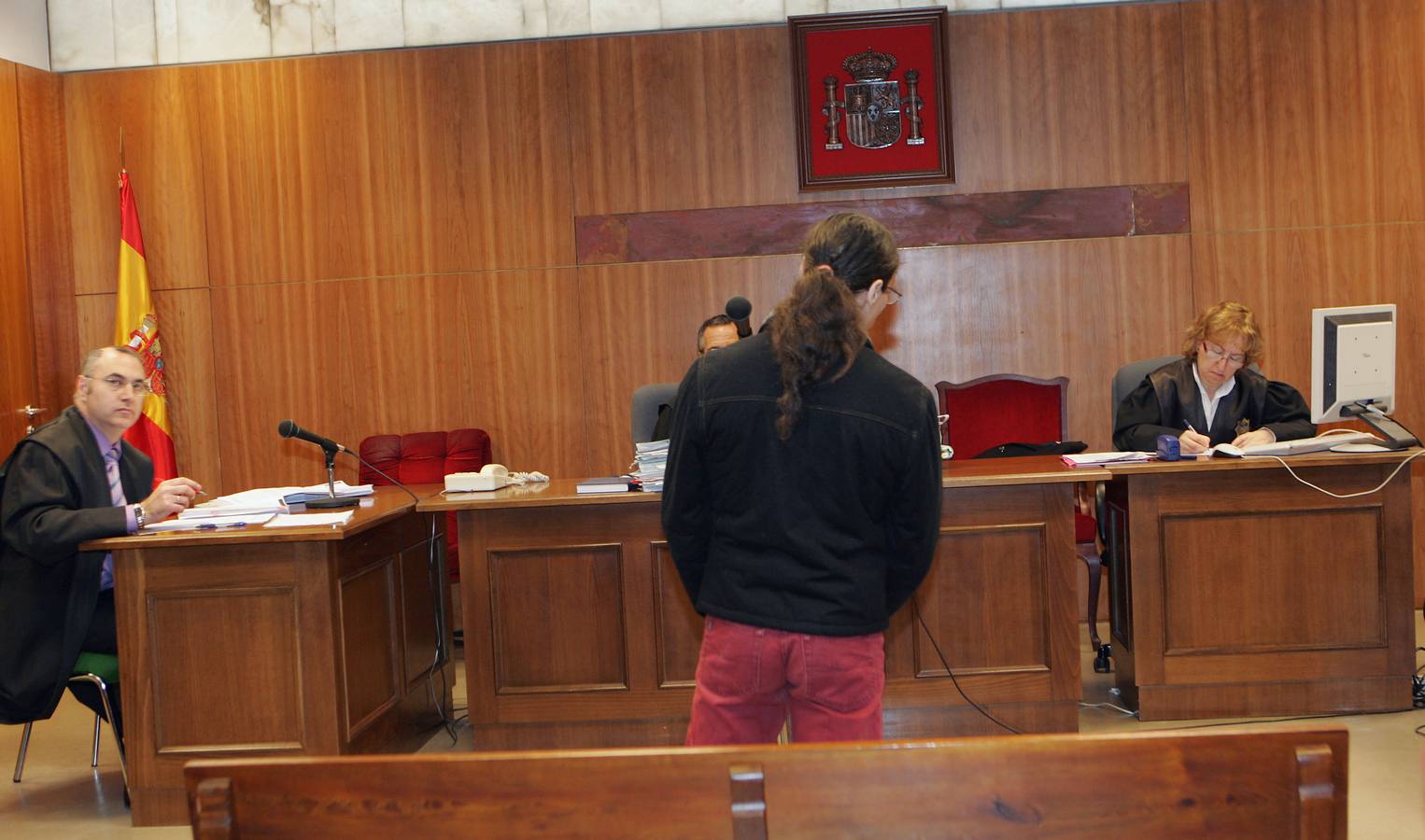 2010. El acusado por sus vecinos del portal 27 del paseo de Farnesio de hacerles 'la vida imposible', de espaldas, presta declaración ante la atenta mirada de su abogado defensor (izquierda) en el Juzgado de lo Penal 2.