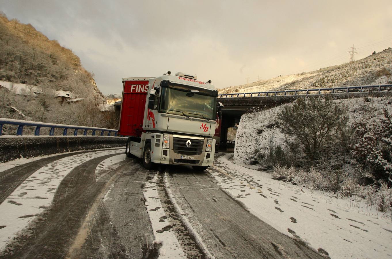 Un camión corta el acceso a la autovía A6 desde la localidad de Pereje (León), al cruzarse por las placas de hielo en la calzada.