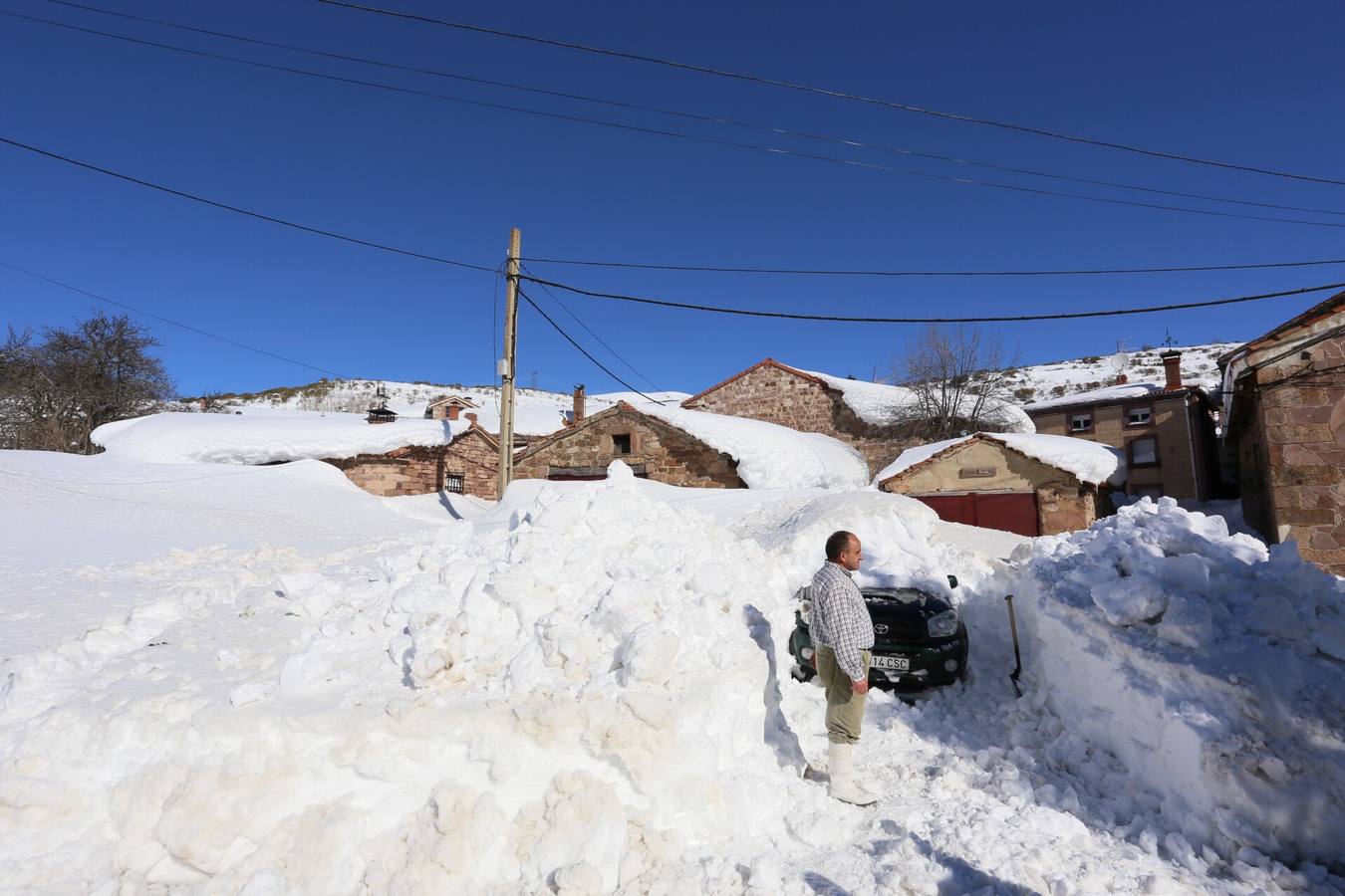Elías vecino de Brañosera quita la nieve de su vehículo.
