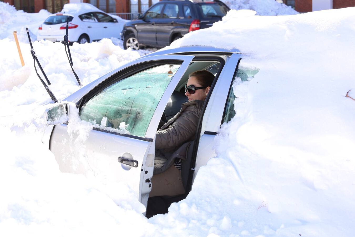 Una vecina de Barruelo de Santullán intenta arrancar su vehículo.