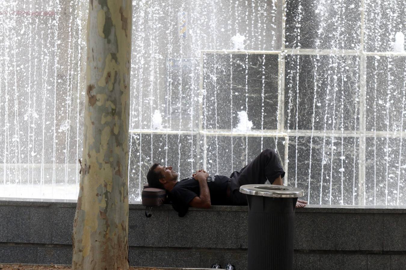 Un hombre descansa junto a una de las fuentes de la ciudad de Córdoba.