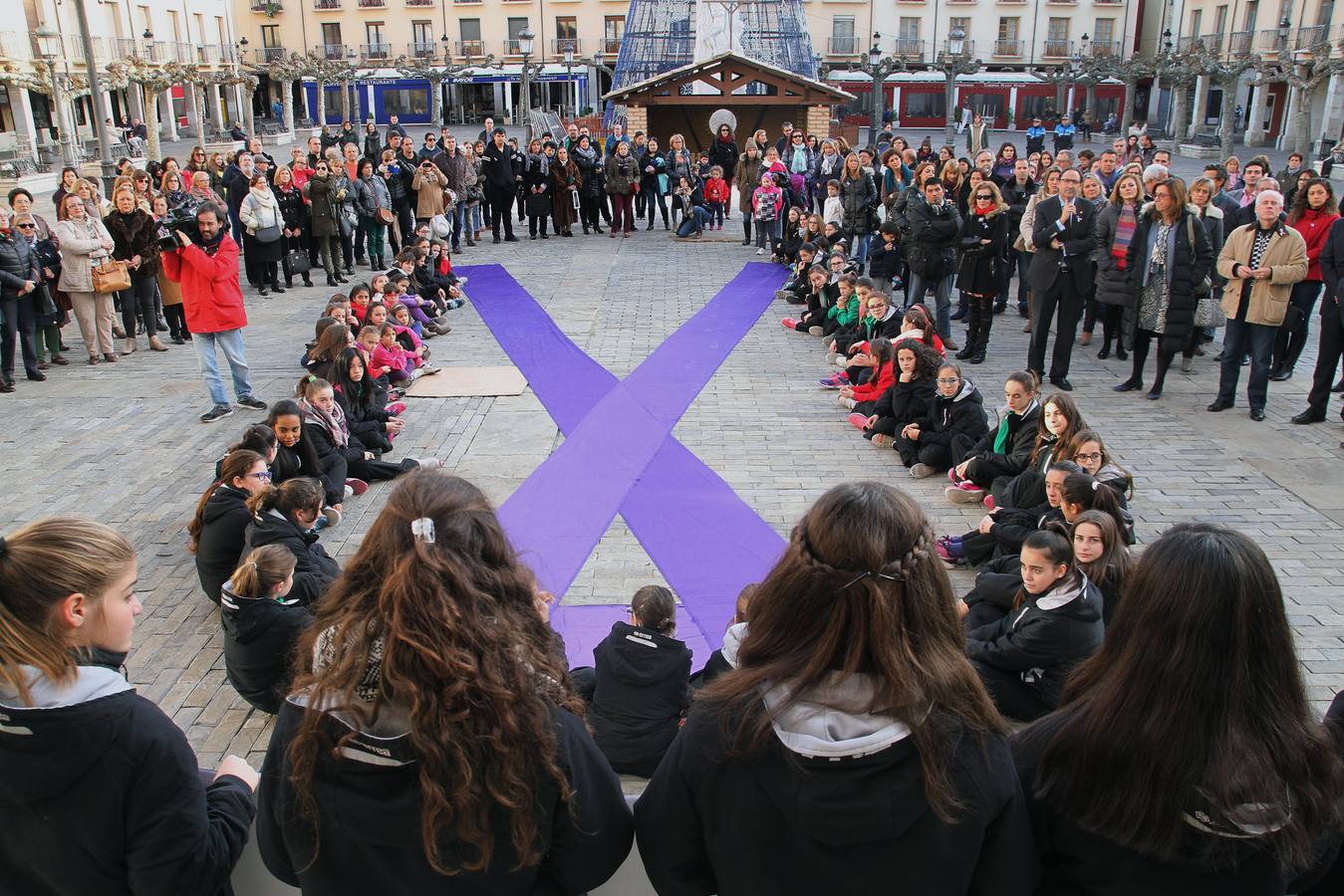 Acto en la plaza Mayor de Palencia, donde se ha leido el manifiesto y las integrantes del equipo femenino de balonmano Palencia han rodeado un gran lazo morado.
