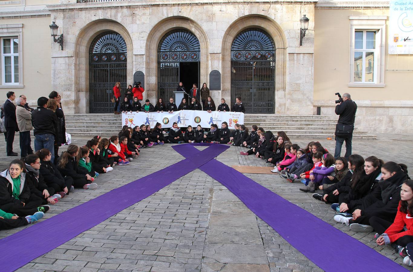 Acto en la plaza Mayor de Palencia, donde se ha leido el manifiesto y las integrantes del equipo femenino de balonmano Palencia han rodeado un gran lazo morado.