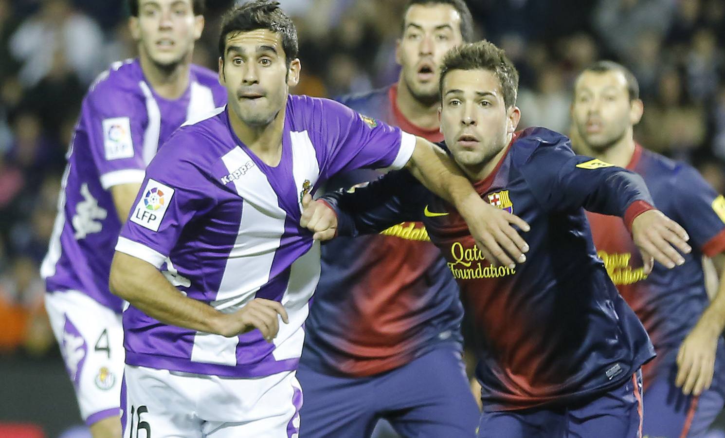 Lluis Sastre y Jordi Alba se agarran en un saque de esquina mientras siguen atentamente el vuelo del balón.