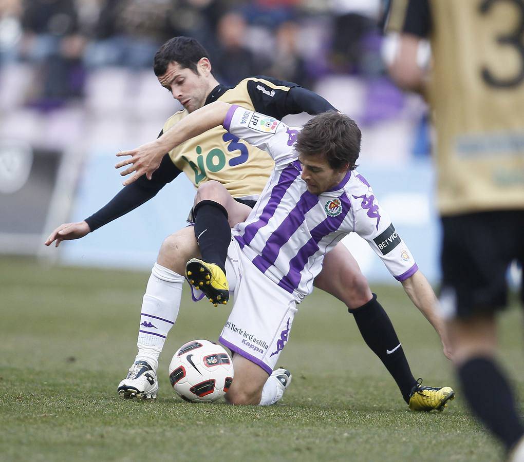 Álvaro Antón trata de sujetar la pelota ante el acoso de un rival.