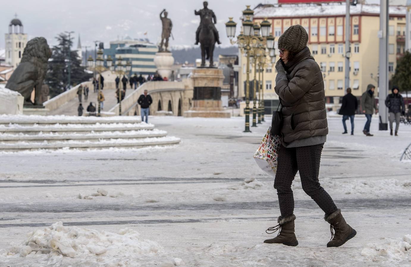 Una mujer camina por la plaza principal cubierta de nieve y hielo en Skopje, Macedonia.