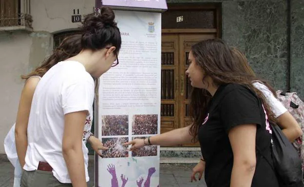 Cuatro jóvenes miran el monolito del chúndara, en la plaza de España. 
