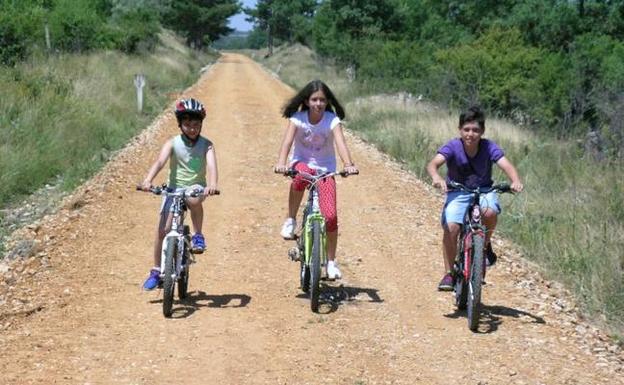 Tres niños circulan en biciceta por la Vía Verde de Soria.
