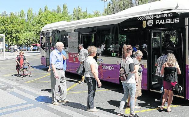 Un grupo de usuarios se dispone a subir a un autobús en la Plaza de León. 