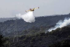 Un helicóptero realiza una descarga de agua durante las labores de extinción del fuego. 