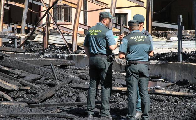 La Guardia Civil examina el lugar del incendio horas después de haber sido extinguido. 