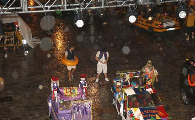 Unos resignados peñistas en la Plaza Mayor, durante el aguacero. 