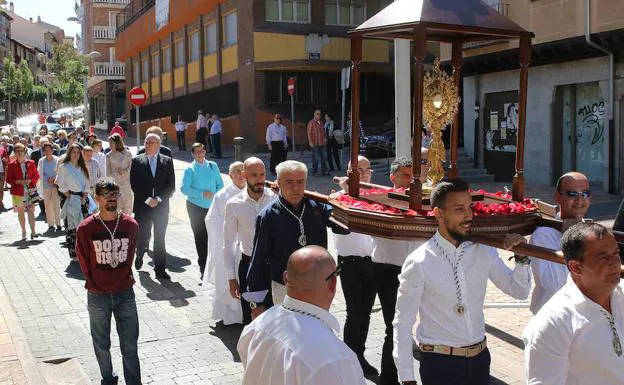 Los portadores transportan al Santísimo en la procesión, acompañados de autoridades y feligreses. 