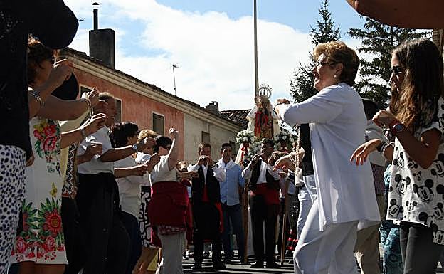 Los vecinos del barrio del Salvador bailan ante la imagen de la Virgen de la Palma. 