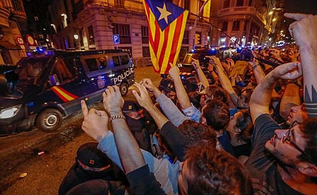 Manifestantes en Barcelona ante un furgón policial.