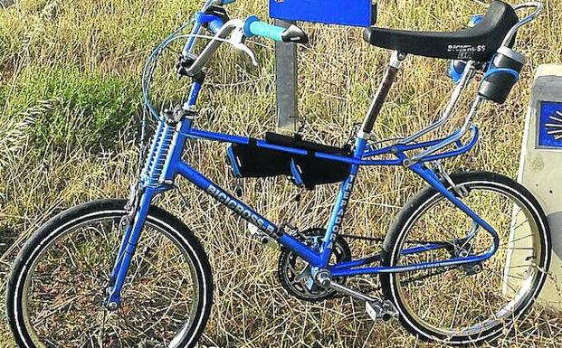 La bicicleta 'La Trepadora', apoyada en una señal del Camino de Santiago