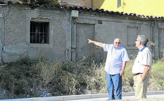 Fructuoso Mangas y José Manuel Hernández junto a una de las pocas casas bajas que se conservan de la anterior época.