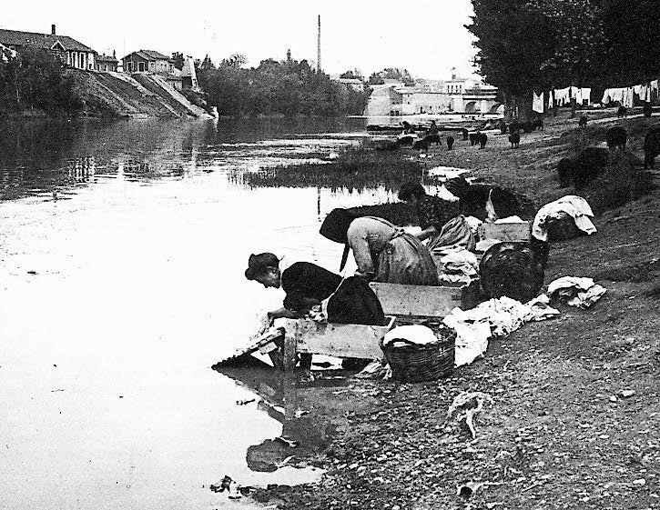 Las lavanderas, en el río Piuserga, con el Puente Mayor de fondo.