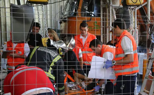 Sanitarios y bomberos atienden a un accidentado. 