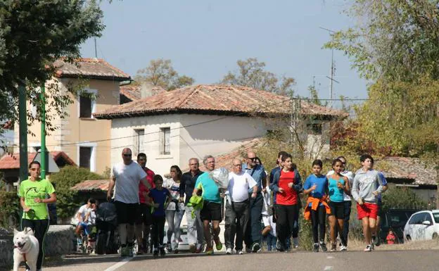 Uno de los relevistas es acompañado por ciudadanos en las inmediaciones del Henar.