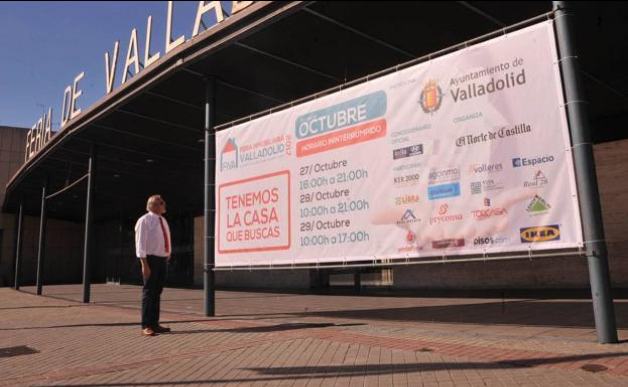 Un hombre observa el cartel anunciador de la Feria Inmobiliaria, junto a la Feria de Valladolid.