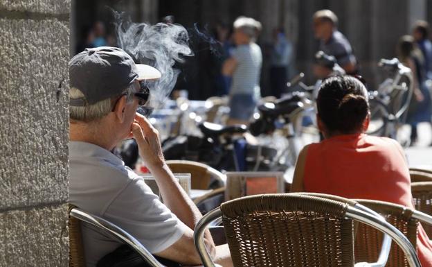 Una persona fumando en una terraza de la capital. 