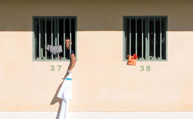 Los inmigrantes argelinos trasladados desde Murcia al Centro Penitenciario de Archidona (Málaga), sin uso desde su construcción, sacan camisetas y gritan en el interior de los módulos. 