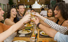 Unos amigos celebran brindan en una cena de Navidad. 