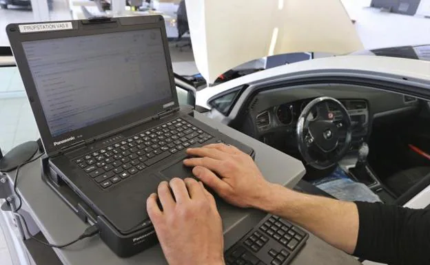 Un mecánico actualiza el programa de Volkswagen Golf Diesel para reparar el 'software' trucado. 