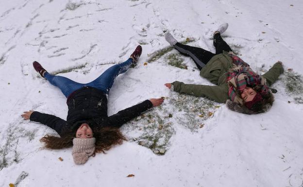 Dos jóvenes juegan en la nieve en Soria capital. 