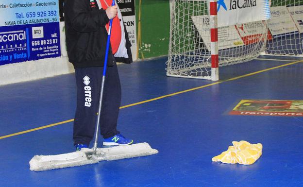 Un operario seca la pista del pabellón de Nava.