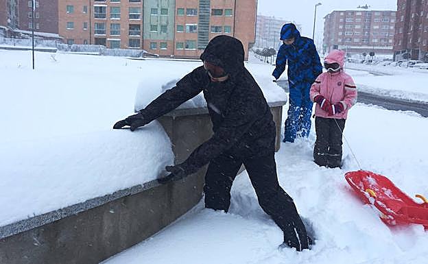Tres niños disfrutan con la nieve en Ávila.
