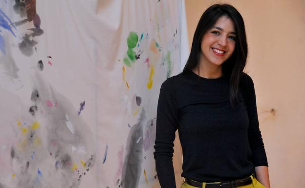 Belén Rodríguez posa con una obra que rinde homenaje a la ropa de trabajo de los pintores. 