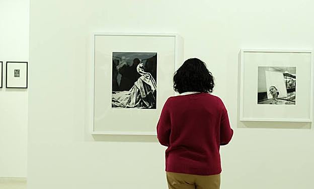 Una visitante observa dos de las fotografías destacadas de la exposición. 