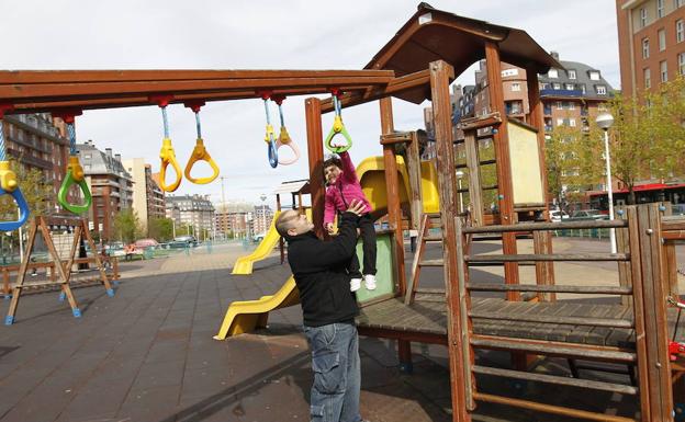 Un padre juega con su hija en el parque.