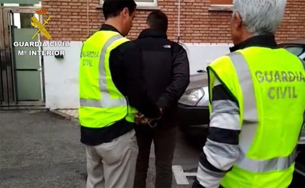 Dos agentes de la Guardia Civil con el profesor detenido. 